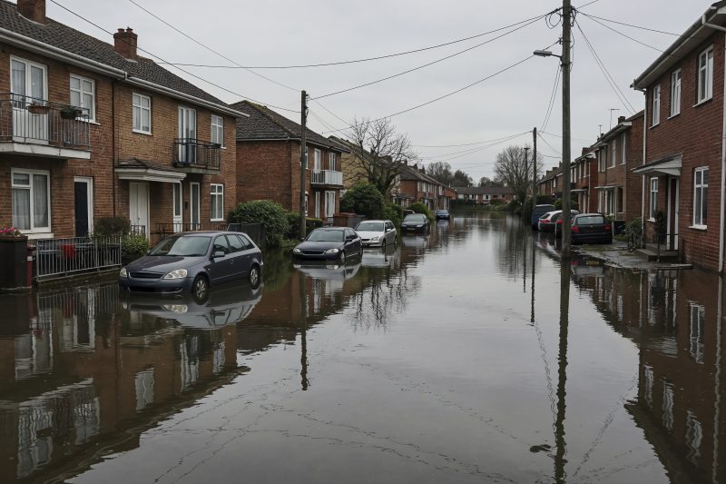 Rue résidentielle inondée, véhicules dans l'eau